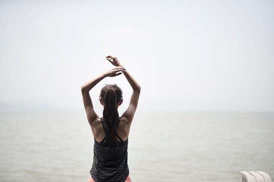 young woman stretching, exercising, well-being