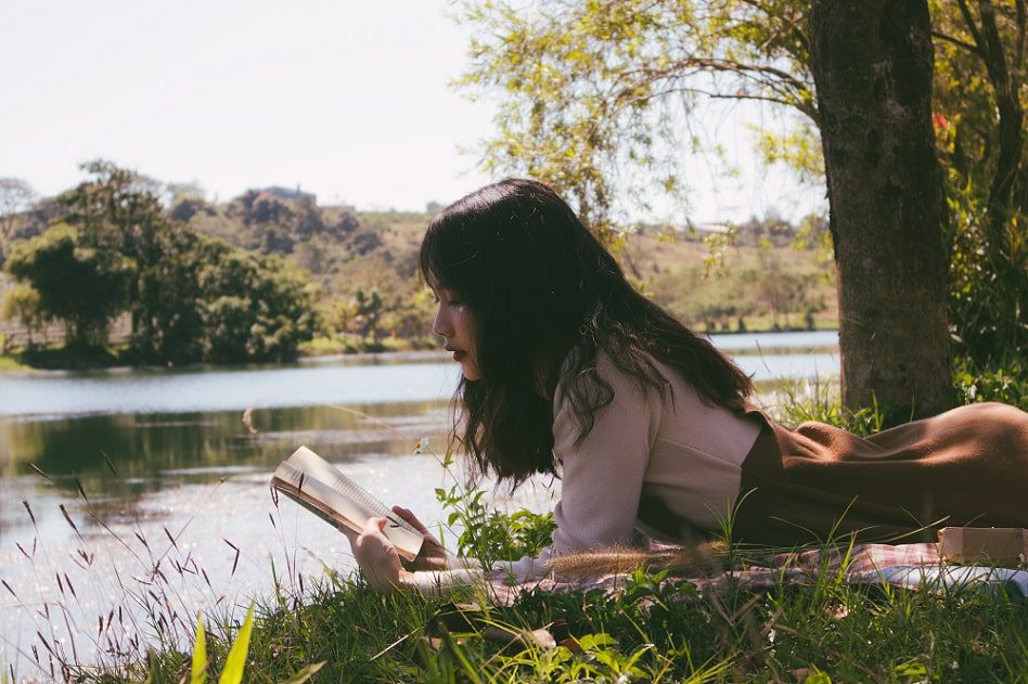 Girl reading book outside