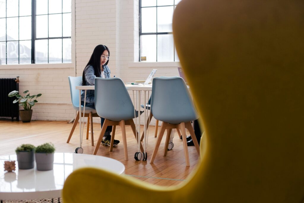 Woman sat at table with laptop.
