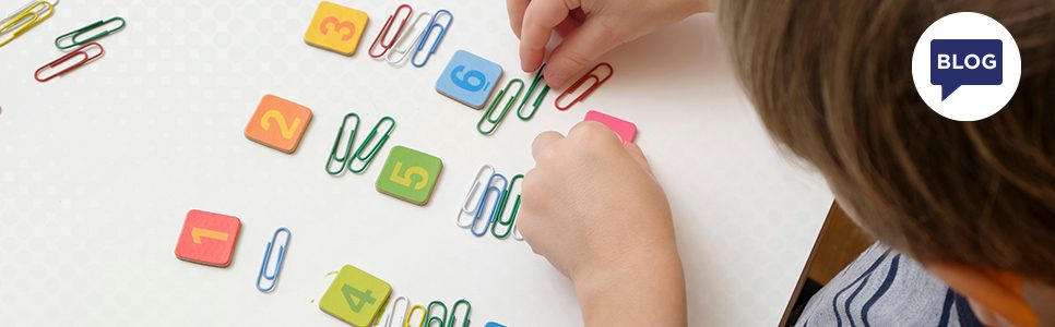 Child counting paper clips banner image.